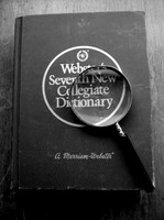 Magnifying glass on dictionary